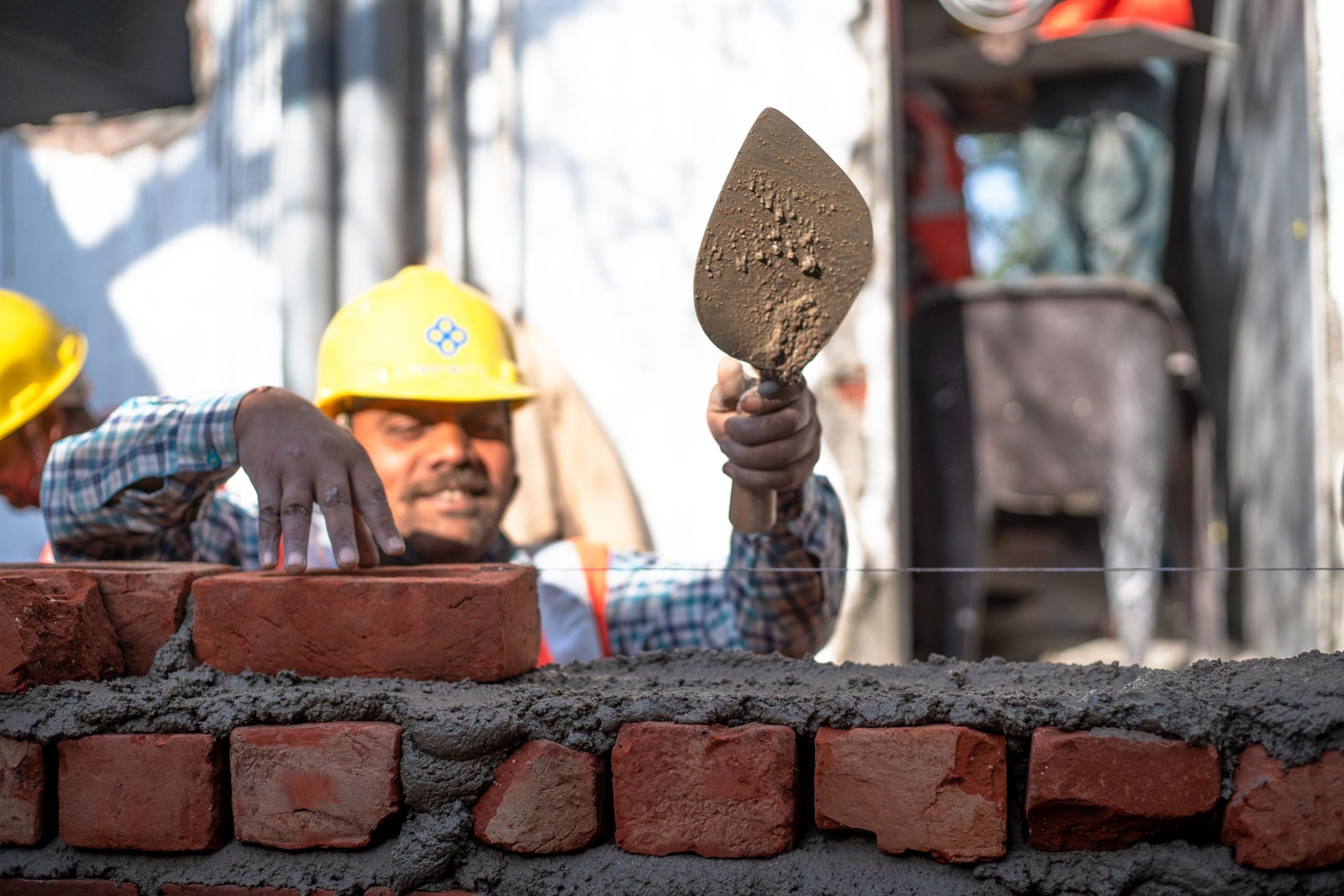 Macons montant un mur en briques sur un chantier