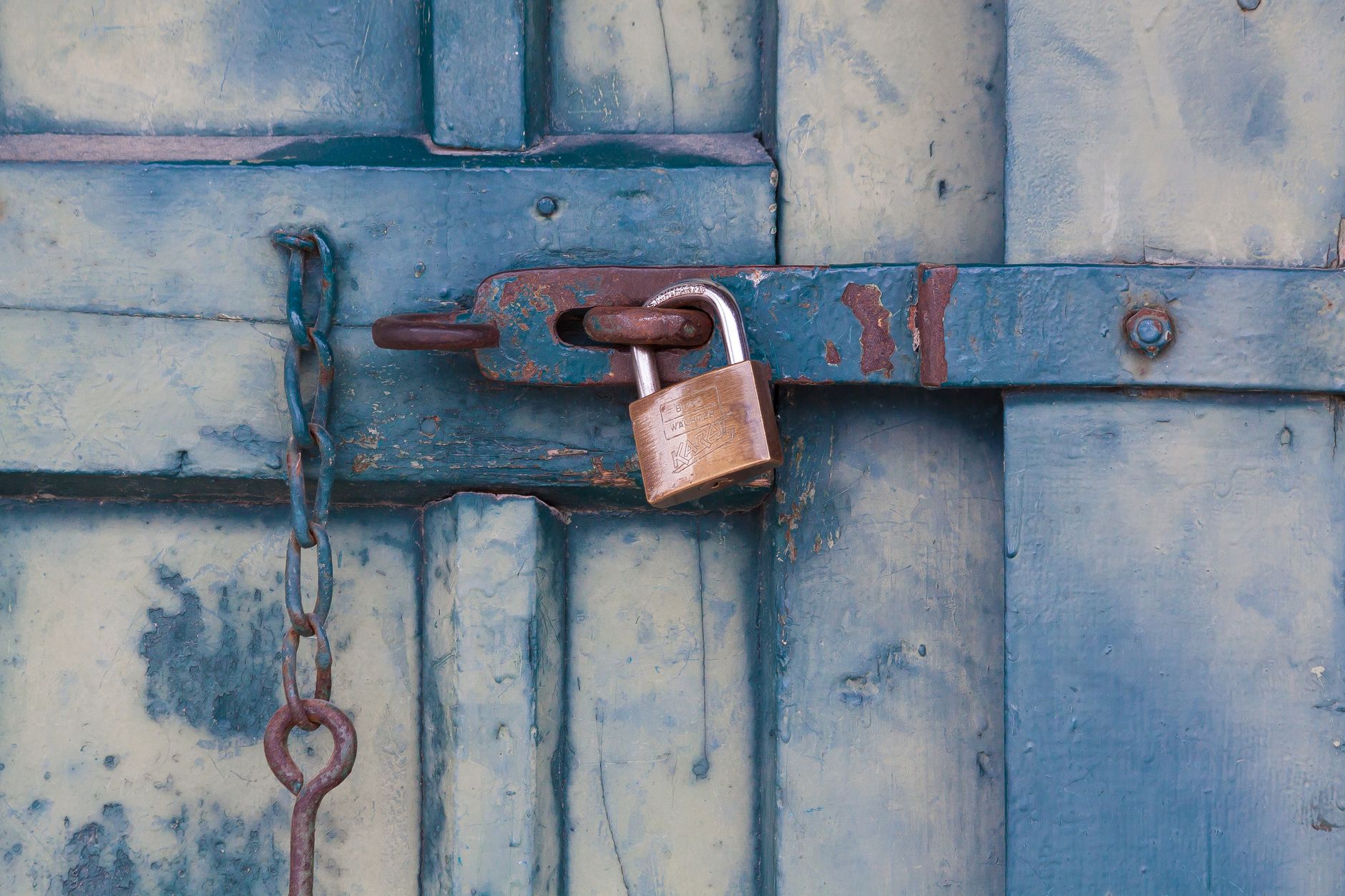 Cadenas rouillé sur une porte en bois peinte en bleu
