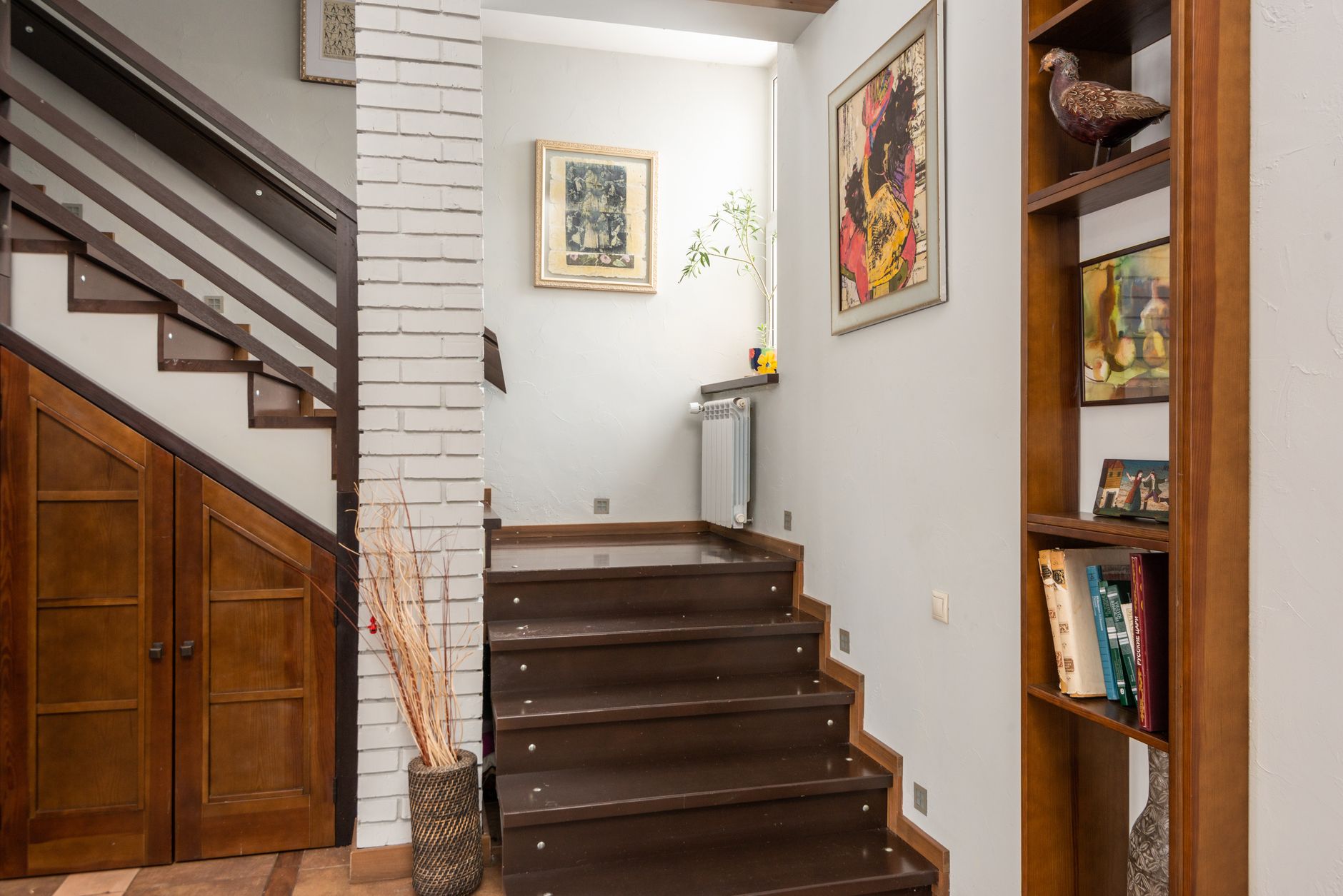 Escalier en bois près d’une colonne en briques dans un appartement