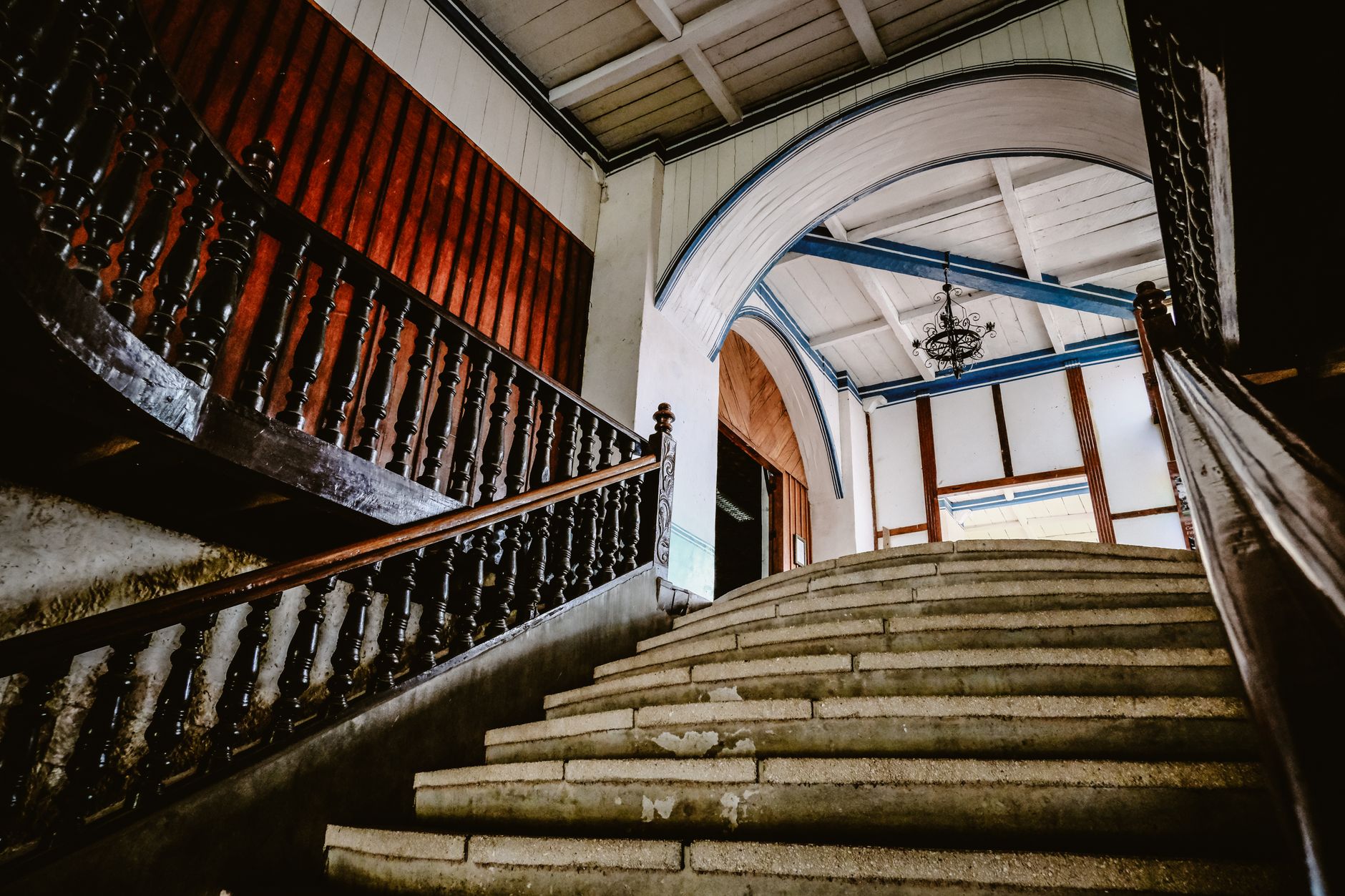 Escalier ancien à rampe en bois ouvragée et arcades