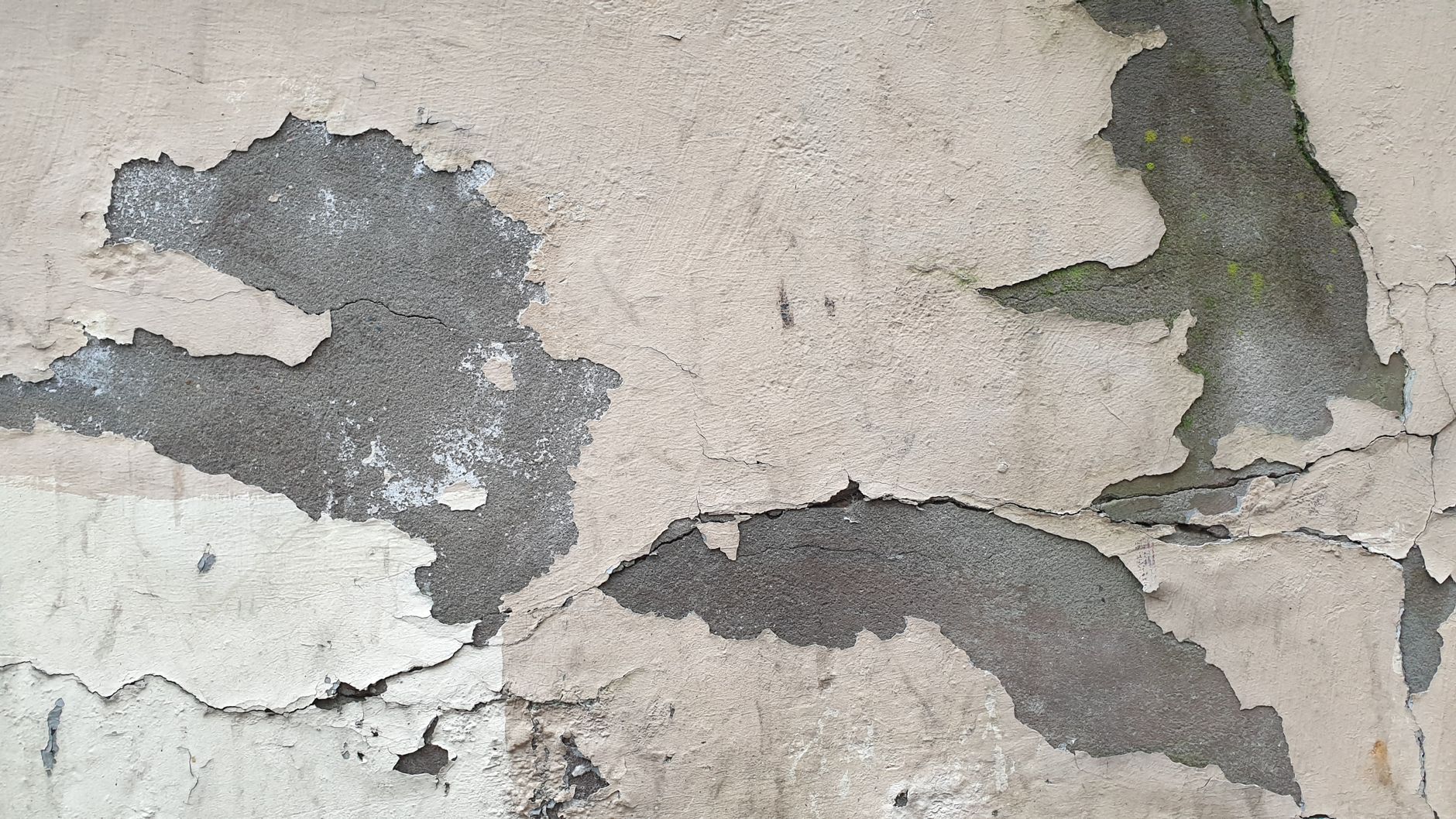 Enduit dégradé et fissuré sur un mur ancien