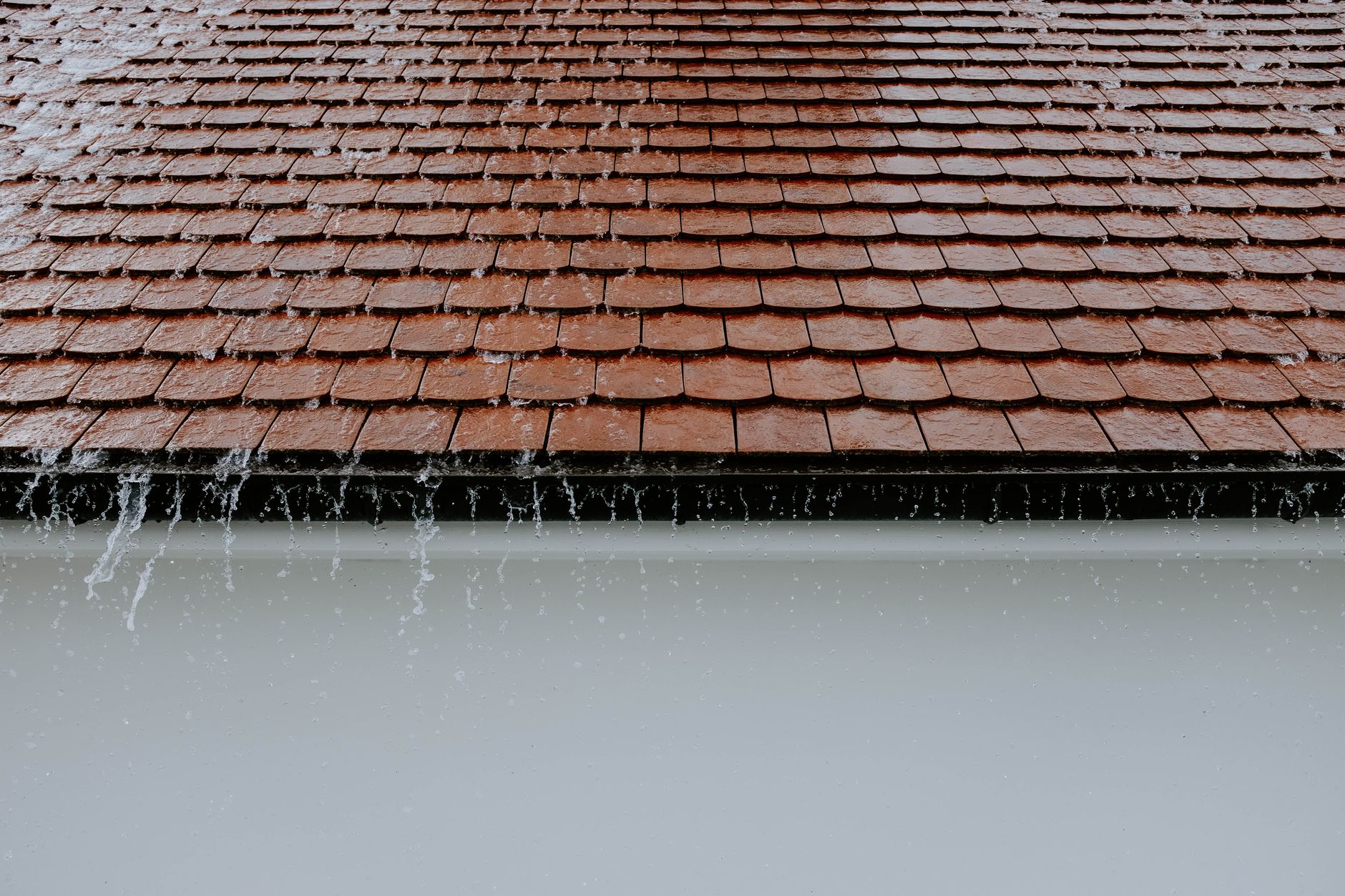 Tuiles brunes avec de l'eau de pluie qui ruisselle